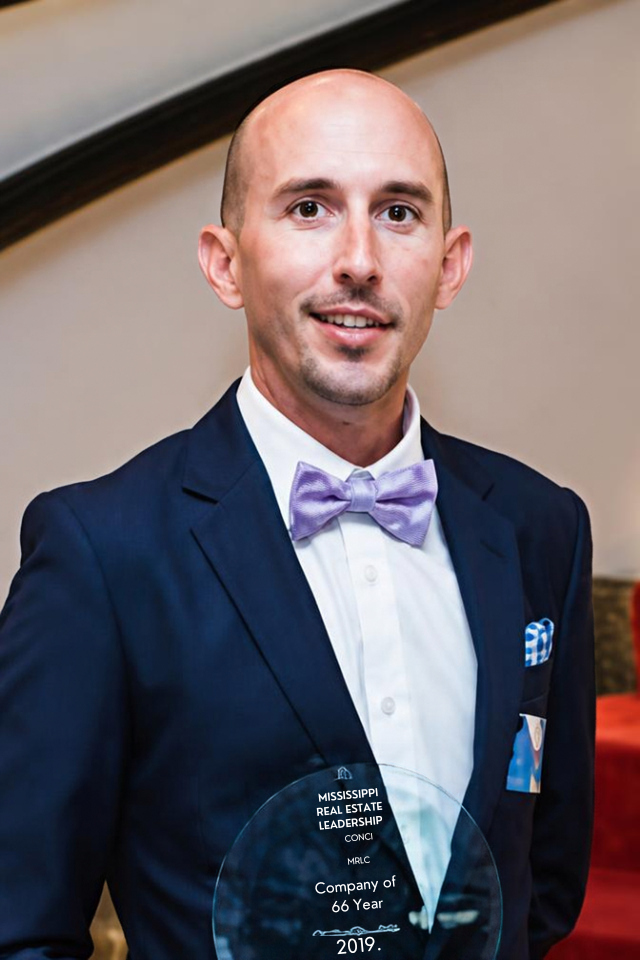 Alumnus Adam Rose wearing a suit