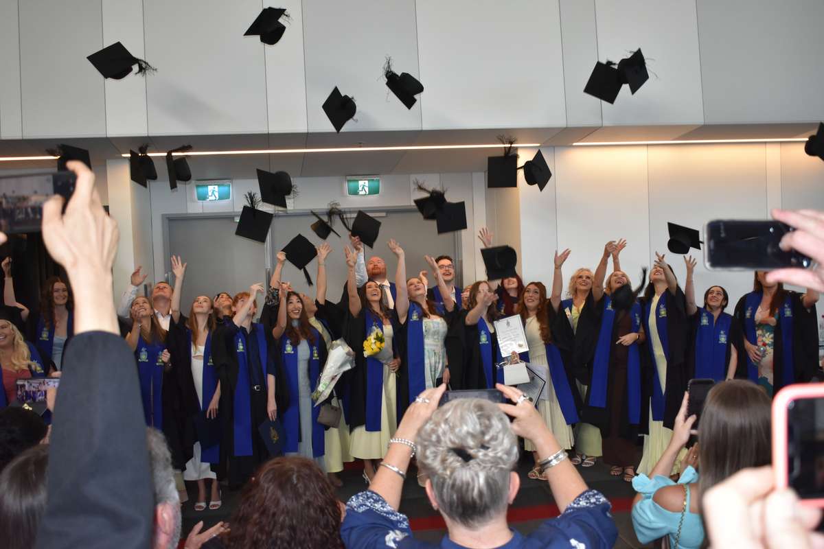 Image of graduates throwing mortarboards