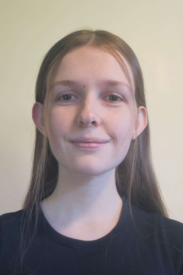 Alumna Zara Costello smiling at the camera wearing a black top